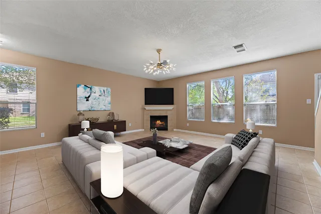 a living room with furniture a flat screen tv and a large window