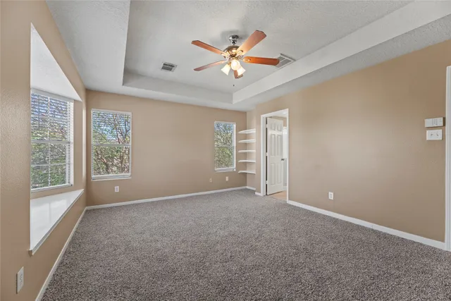 a spacious bedroom with a bed and a chandelier
