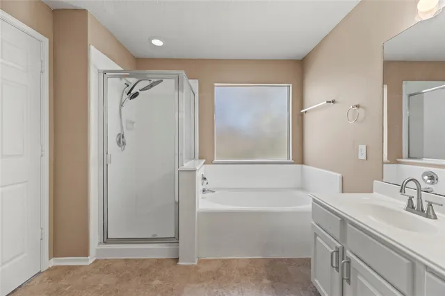 a spacious bathroom with a bathtub sink and mirror