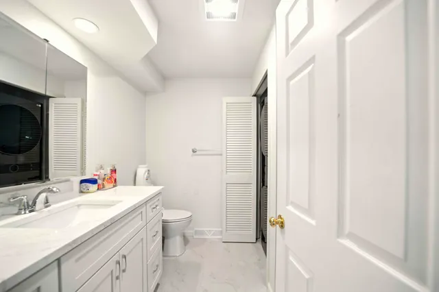 a bathroom with a sink toilet vanity and tub