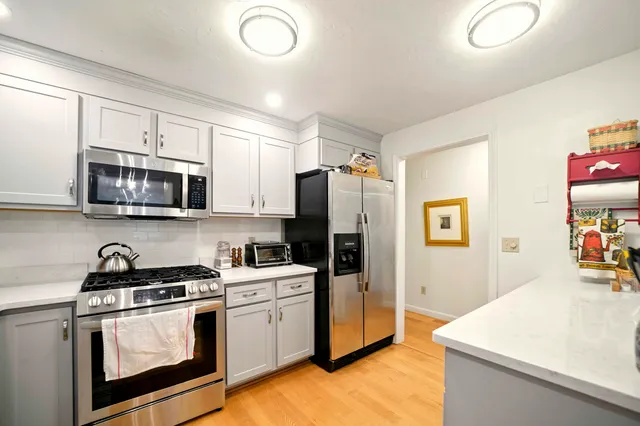 a kitchen with stainless steel appliances a stove microwave sink and refrigerator