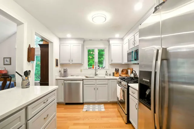 a kitchen with stainless steel appliances granite countertop a refrigerator and a sink
