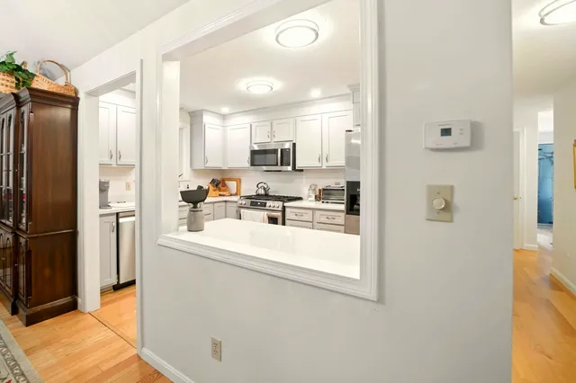 a kitchen with stainless steel appliances a refrigerator sink and white cabinets