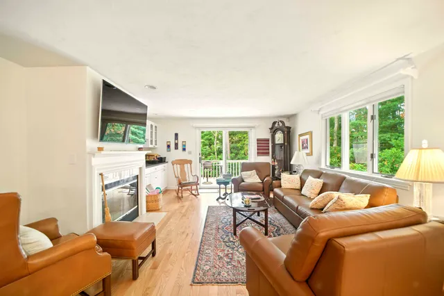a living room with furniture fireplace and a large window