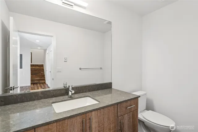 a bathroom with a granite countertop sink and a mirror