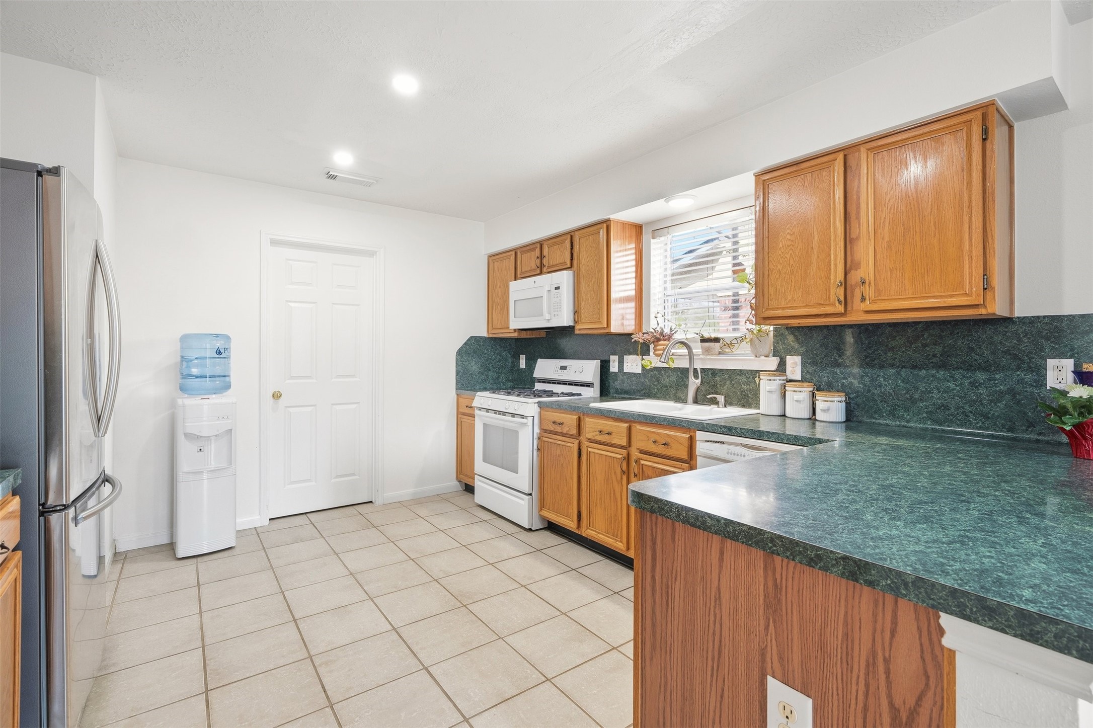 28723 Sedgefield Street Spring, TX 77386 - Photo 9 of 20 a kitchen with stainless steel appliances granite countertop a stove a sink and a microwave