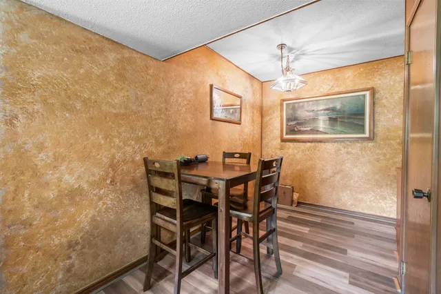 a kitchen with granite countertop a table chairs stove and cabinets