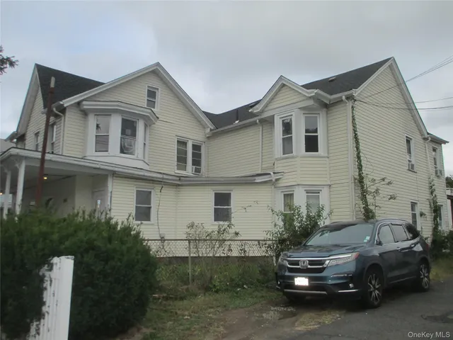 a car parked in front of a white house
