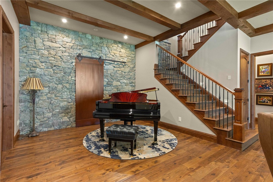 236 Palmer Way Sunset, SC 29685 - Photo 19 of 46 Natural wood flooring complements the rustic stone wall and exposed beam ceiling.