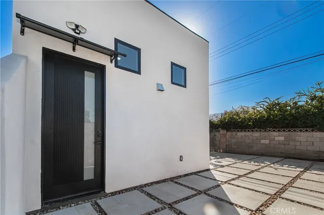 a large white room with kitchen view and a window