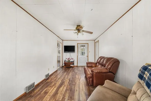 a living room with furniture a ceiling fan and a rug