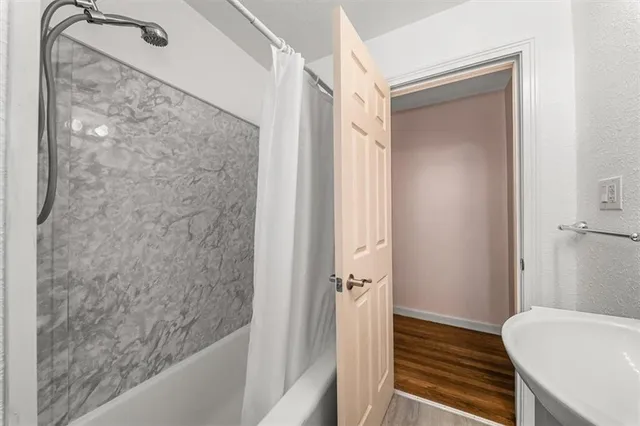 a bathroom with a granite countertop shower and a sink