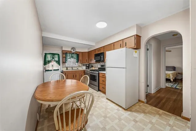 a kitchen with stainless steel appliances granite countertop a refrigerator a stove a sink dishwasher with a dining table and chairs