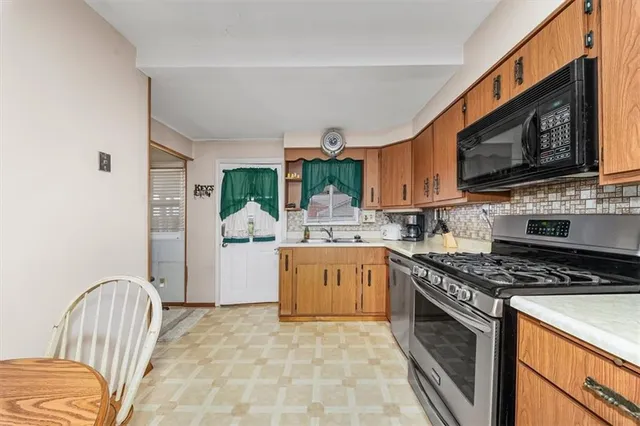 a kitchen with stainless steel appliances granite countertop a stove a sink and a microwave