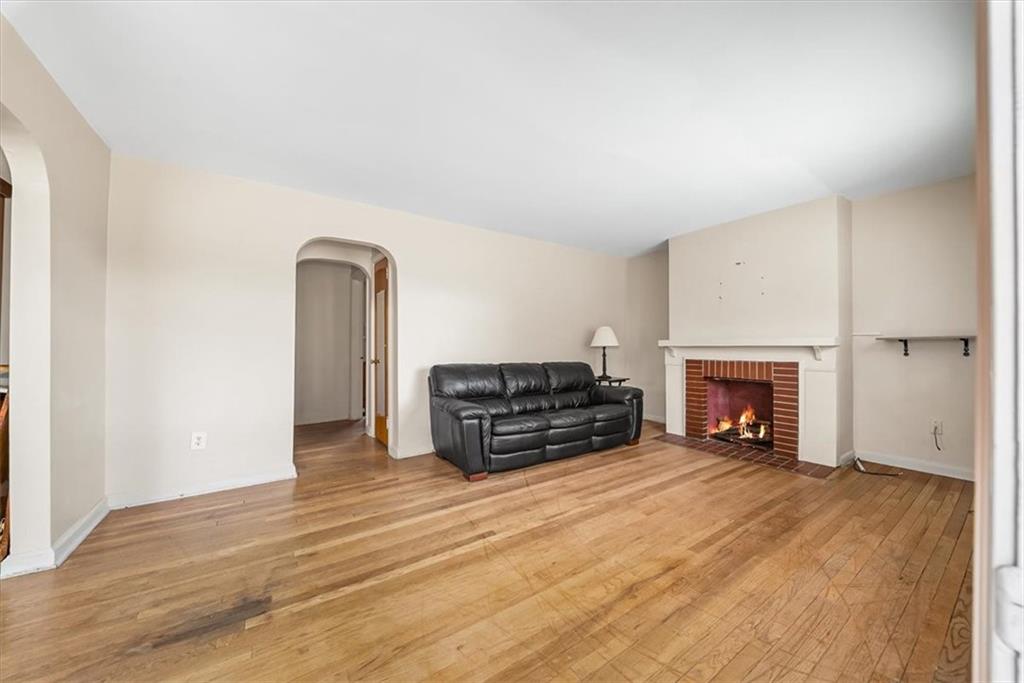 2164 Brodhead Road Aliquippa, PA 15001 - Photo 9 of 28 an empty room with fireplace and wooden floor