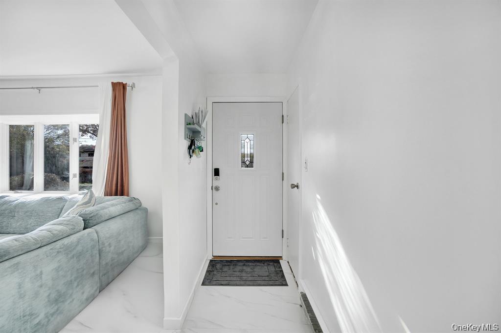 61 South Merrick Road Massapequa, NY 11758 - Photo 7 of 29 Entryway featuring light marble finish flooring and healthy amount of natural light