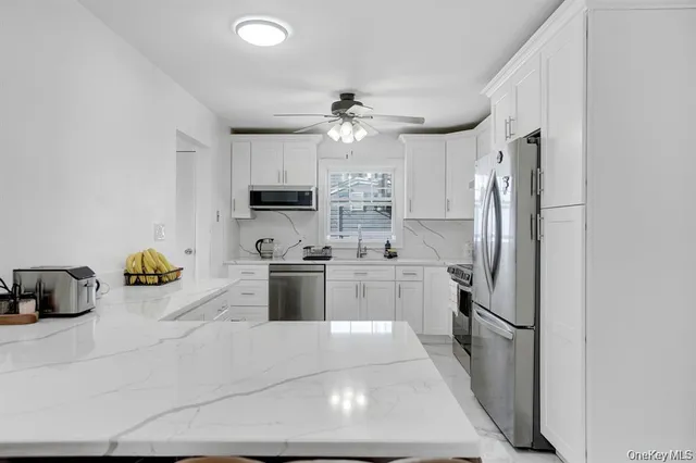a kitchen with stainless steel appliances a refrigerator sink and microwave