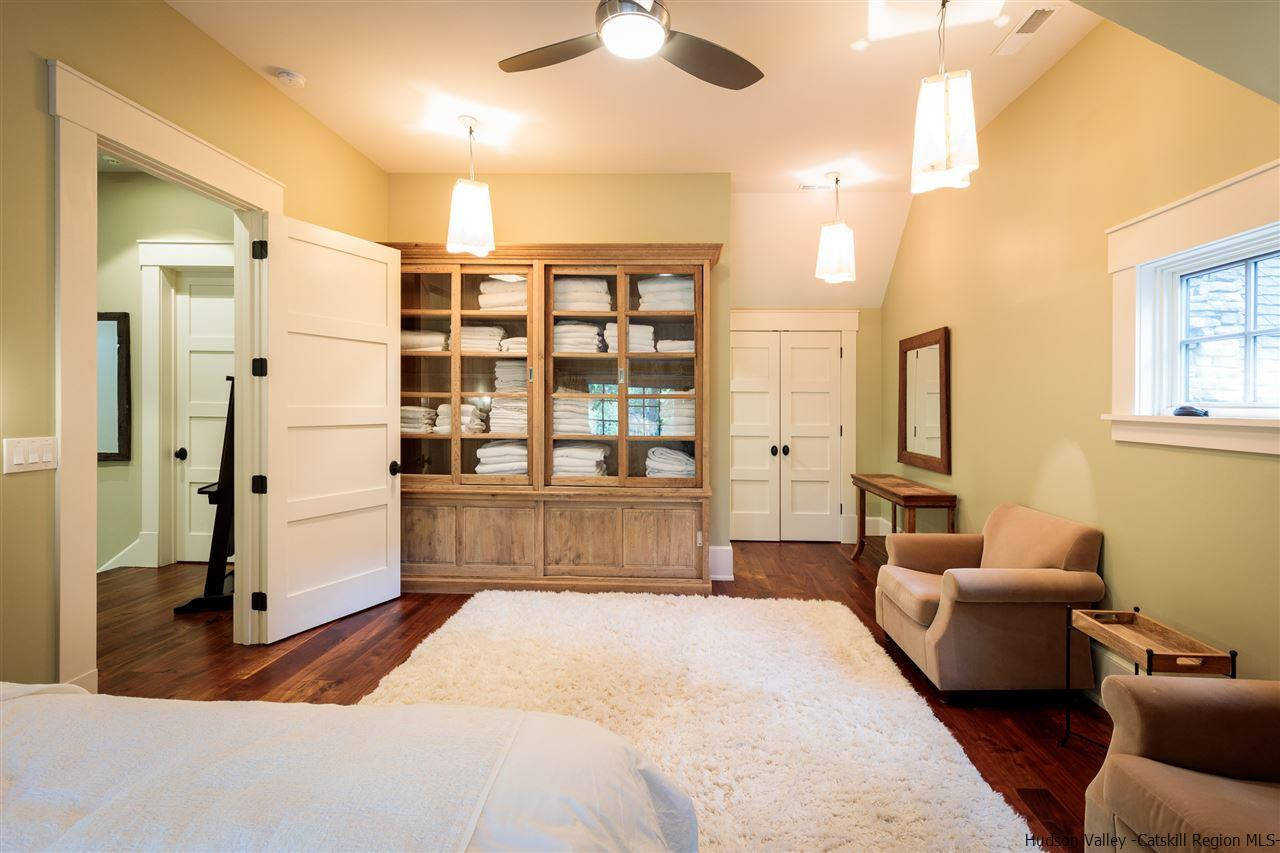 4644 Atwood Road Stone Ridge, NY 12484 - Photo 12 of 26 a spacious bedroom with a large bed and a chandelier