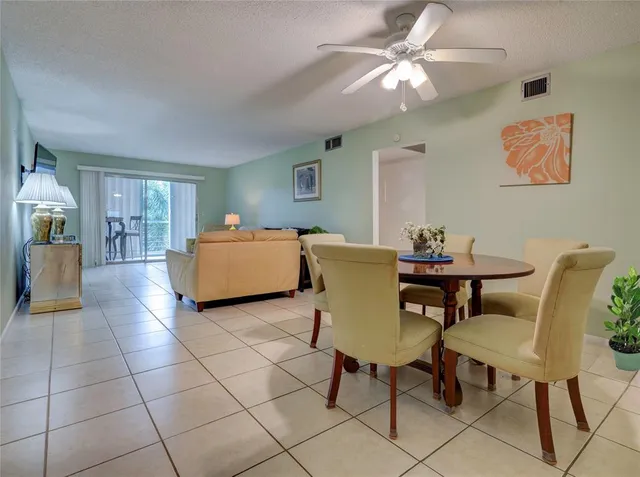a living room with furniture and a dining table with kitchen view