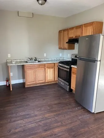 a kitchen with stainless steel appliances granite countertop a refrigerator sink and stove