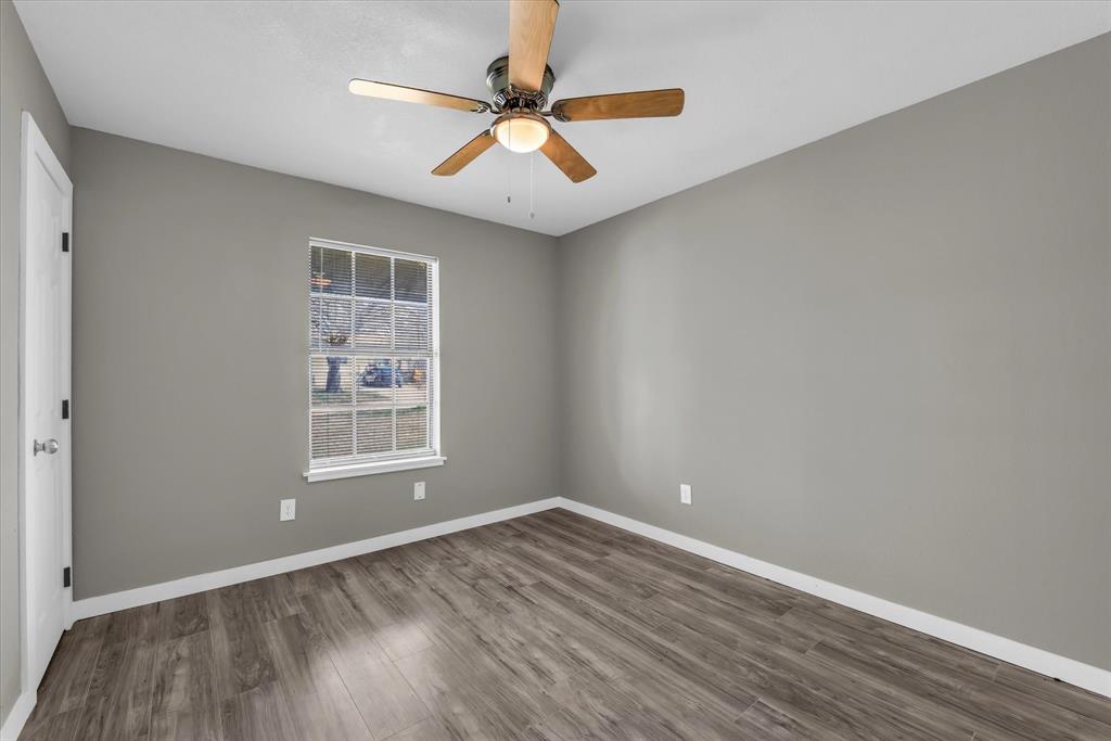 308 South Herman Street Mexia, TX 76667 - Photo 15 of 28 an empty room with wooden floor and windows