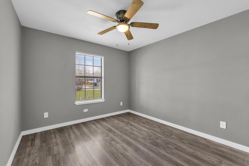 308 South Herman Street Mexia, TX 76667 - Photo 17 of 28 wooden floor in an empty room with a window