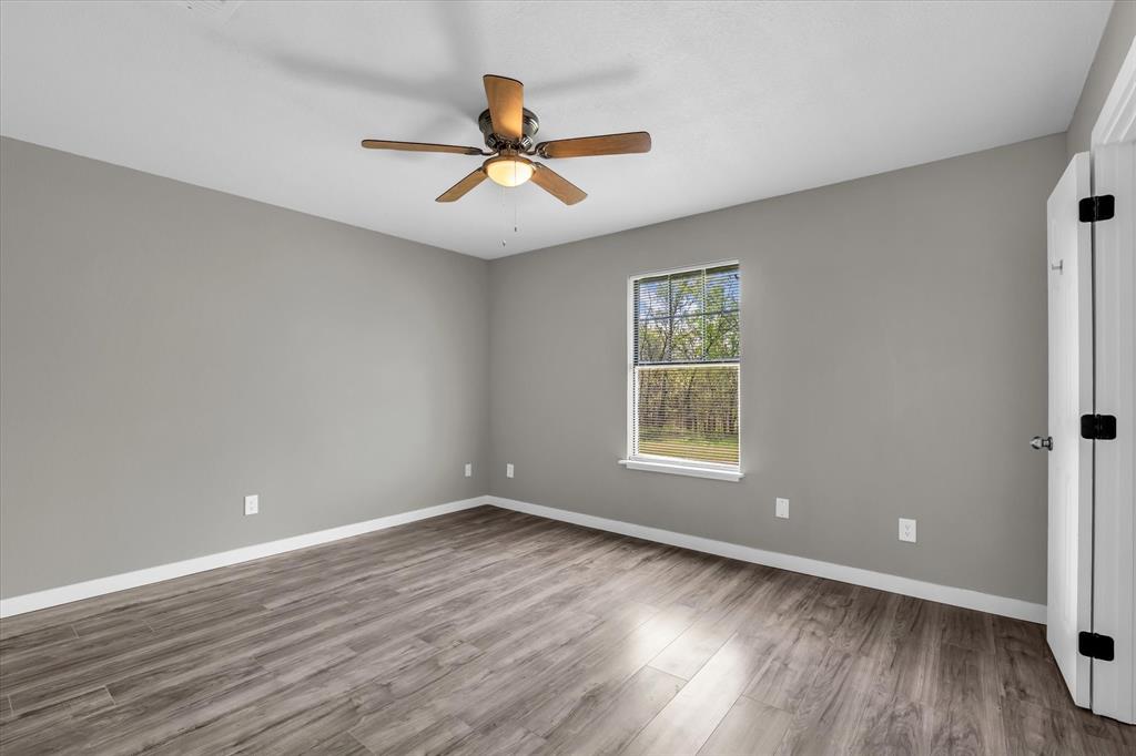 308 South Herman Street Mexia, TX 76667 - Photo 19 of 28 a view of a big room with wooden floor and windows