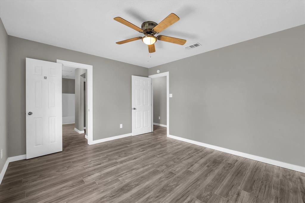 308 South Herman Street Mexia, TX 76667 - Photo 20 of 28 an empty room with wooden floor and ceiling fan