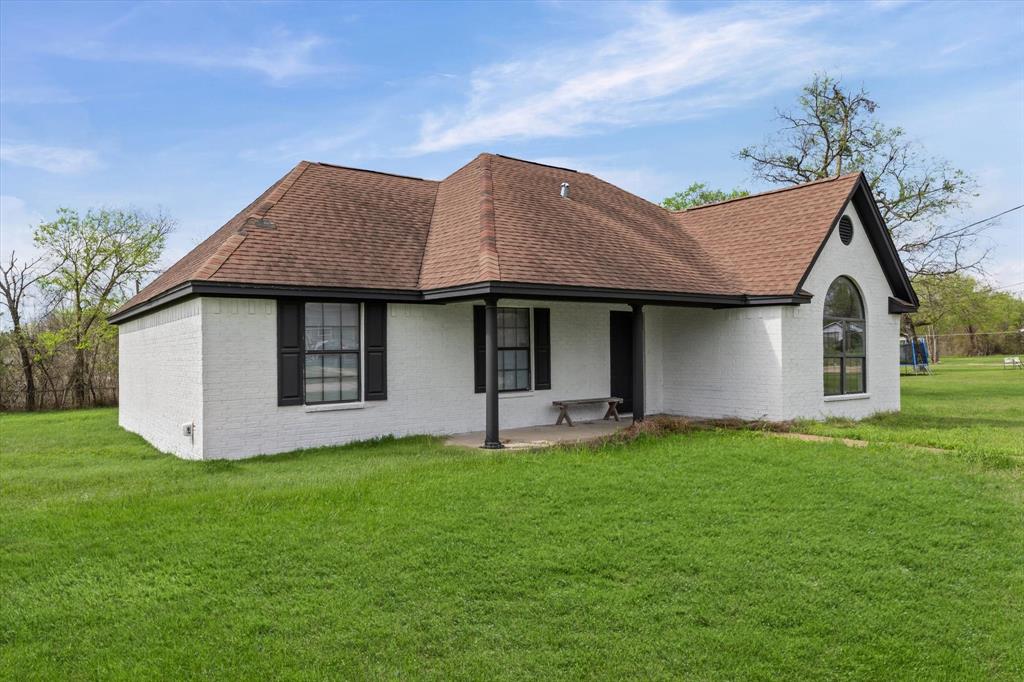308 South Herman Street Mexia, TX 76667 - Photo 2 of 28 a front view of a house with a yard and garage