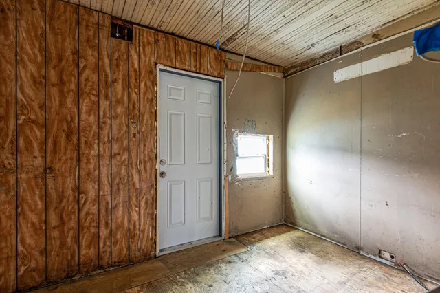 a view of a hallway with wooden walls
