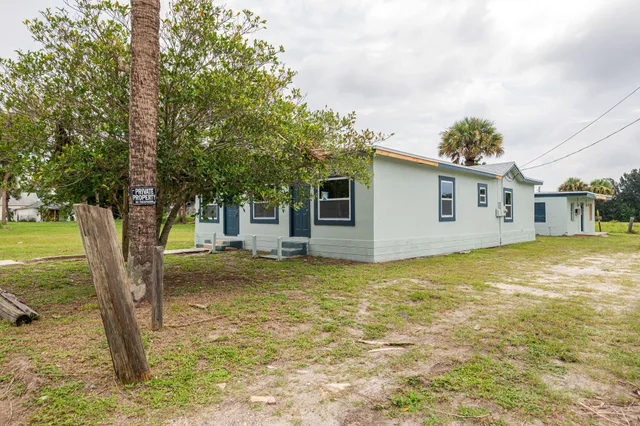 a backyard of a house with table and chairs