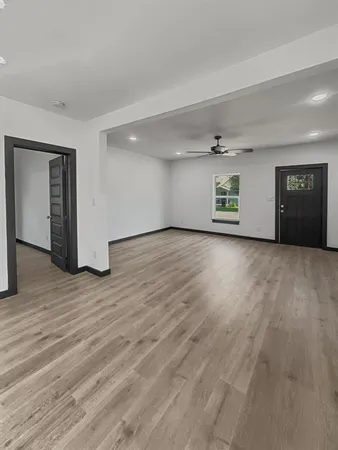a view of an empty room with wooden floor