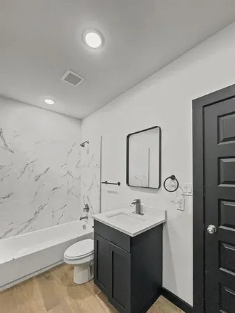 a bathroom with a toilet sink and mirror
