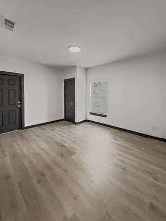 a view of an empty room with wooden floor