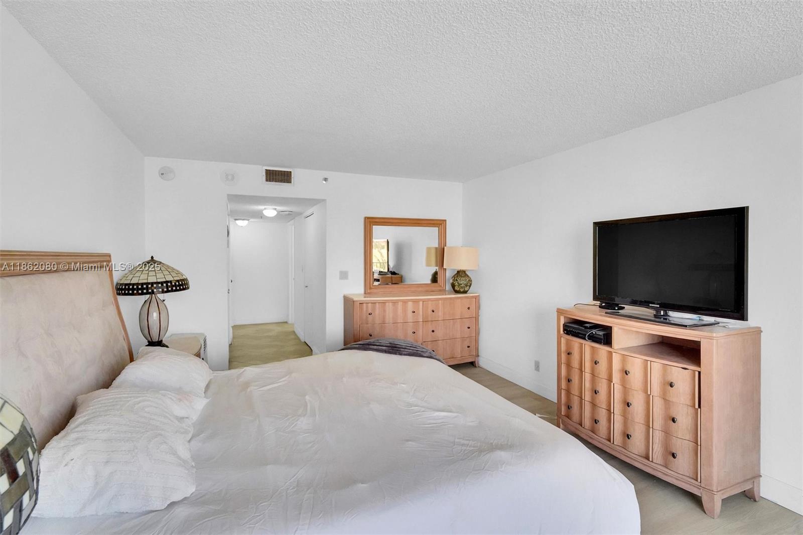 8877 Collins Avenue, Unit 405 Surfside, FL 33154 - Photo 14 of 21 a bedroom with a bed and a flat screen tv