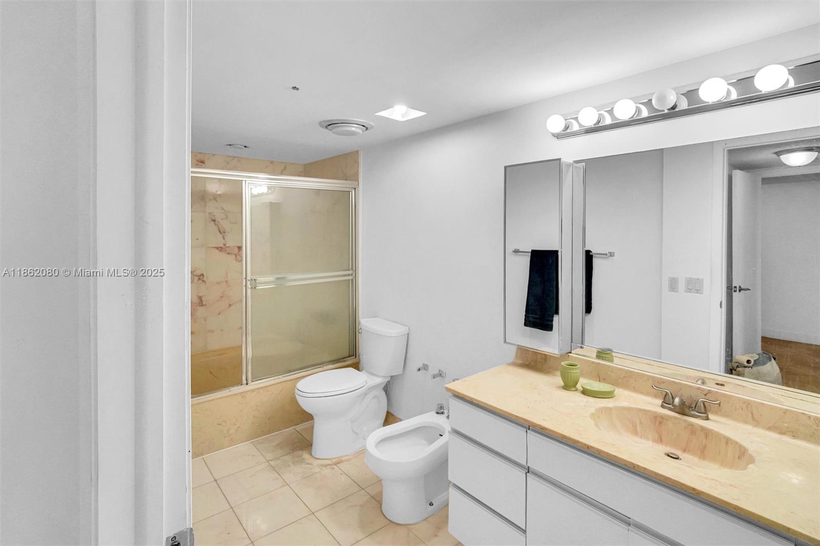 8877 Collins Avenue, Unit 405 Surfside, FL 33154 - Photo 16 of 21 a bathroom with a sink toilet and shower