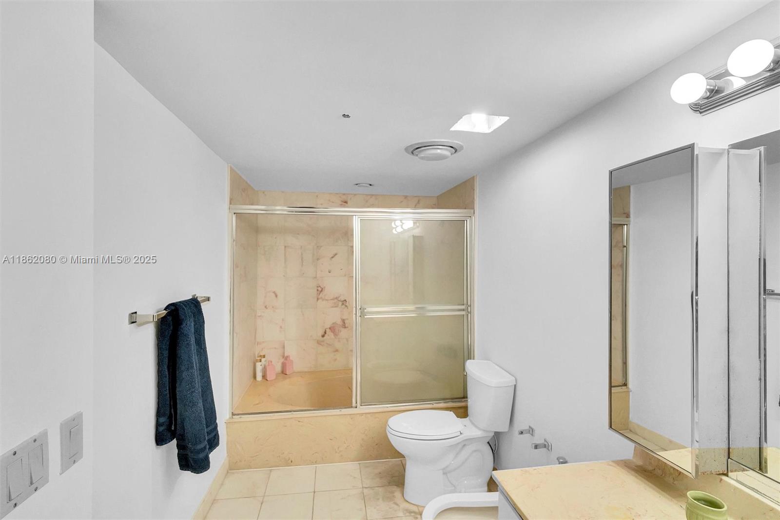 8877 Collins Avenue, Unit 405 Surfside, FL 33154 - Photo 17 of 21 a bathroom with a toilet and a shower