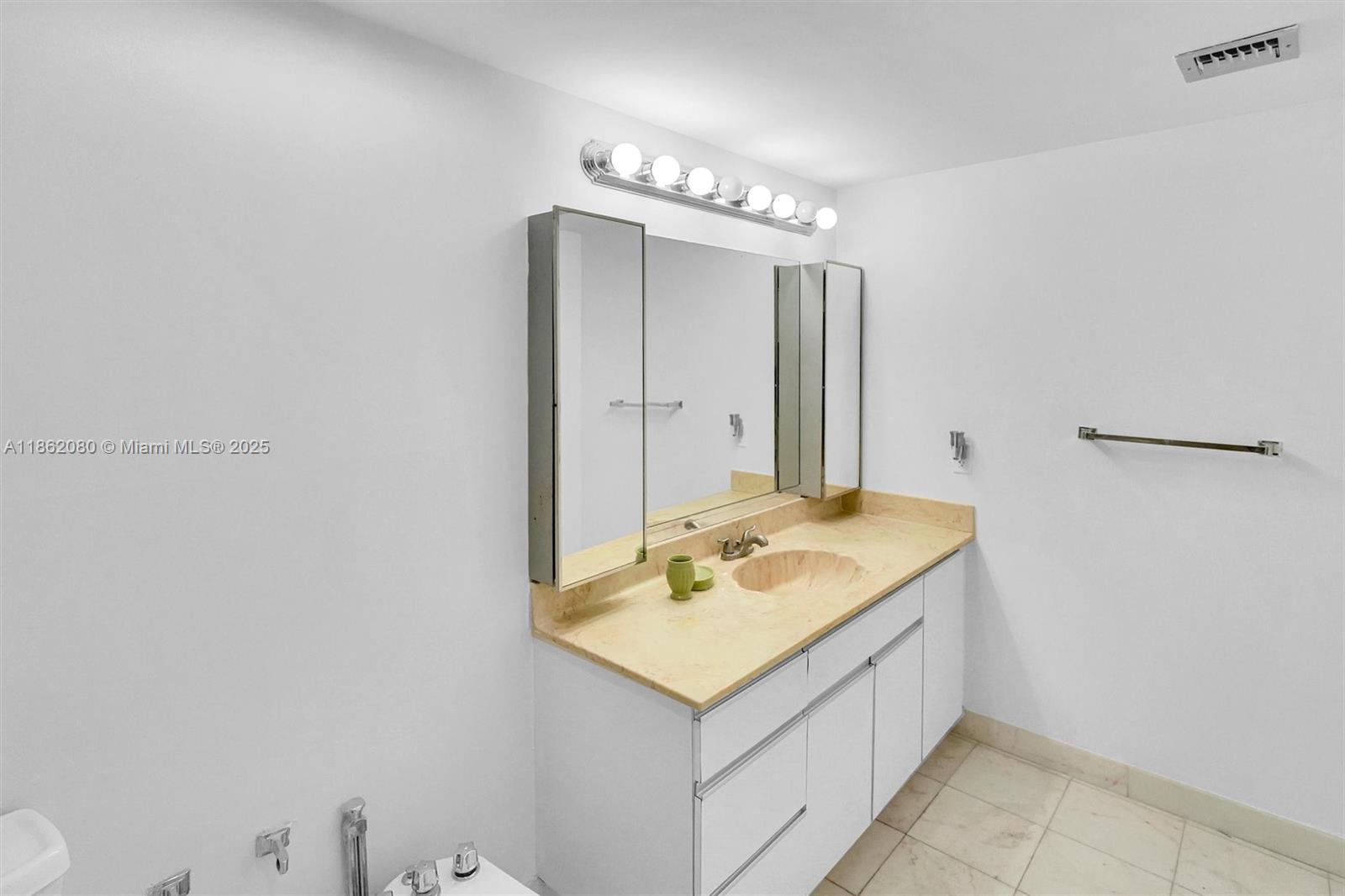 8877 Collins Avenue, Unit 405 Surfside, FL 33154 - Photo 18 of 21 a bathroom with a sink and a mirror