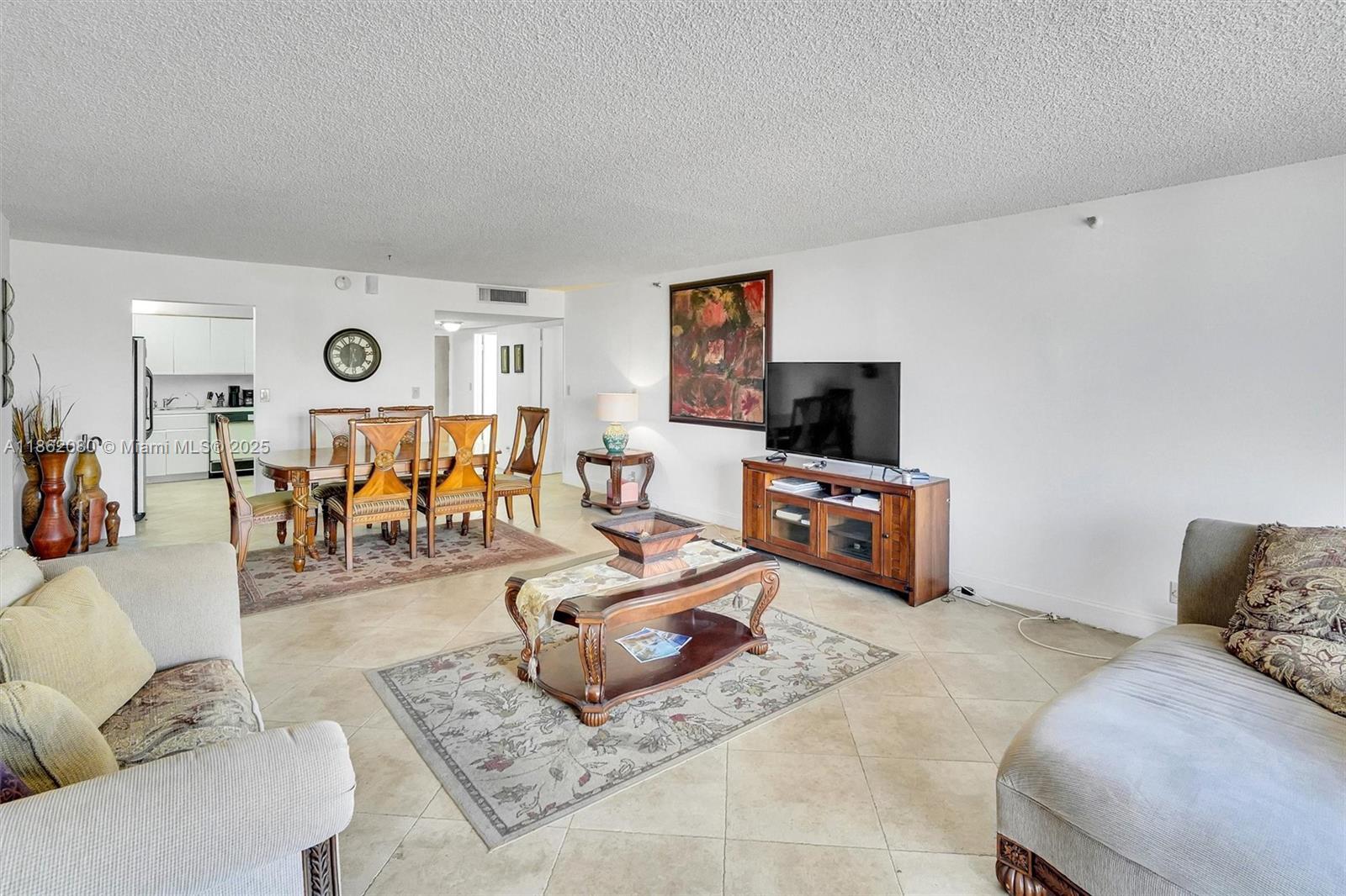 8877 Collins Avenue, Unit 405 Surfside, FL 33154 - Photo 6 of 21 a living room with furniture and a flat screen tv