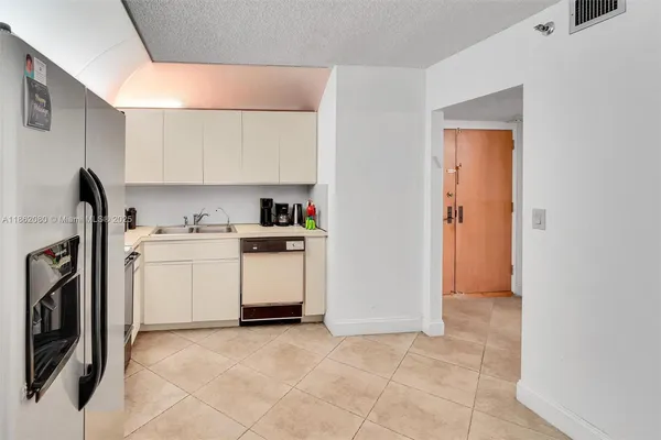 a view of a kitchen with white cabinets and wooden floor