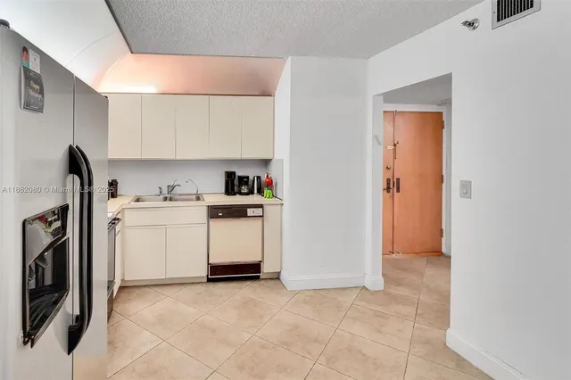a view of a kitchen with white cabinets and wooden floor