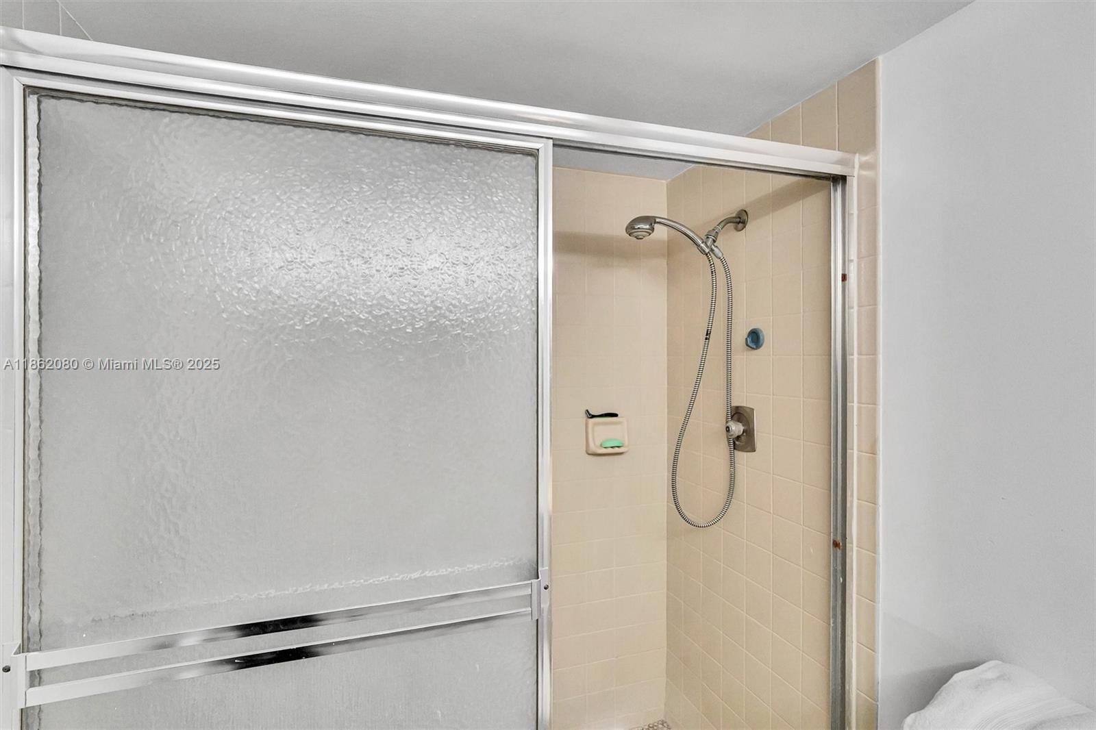 8877 Collins Avenue, Unit 405 Surfside, FL 33154 - Photo 10 of 21 a bathroom with a glass shower door