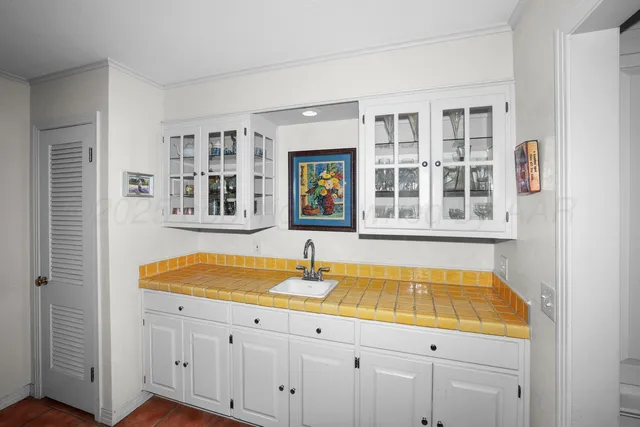 a view of a kitchen with granite countertop a sink and dishwasher with wooden cabinets