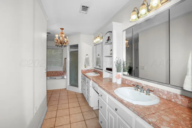 a spacious bathroom with a granite countertop sink a mirror and a shower