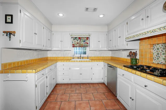 a kitchen with a sink window and cabinets