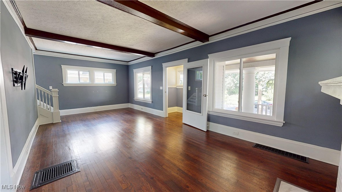 3174 Oak Road Cleveland, OH 44118 - Photo 7 of 33 Unfurnished living room featuring beamed ceiling, hardwood / wood-style floors, a textured ceiling, stairs, and crown molding
