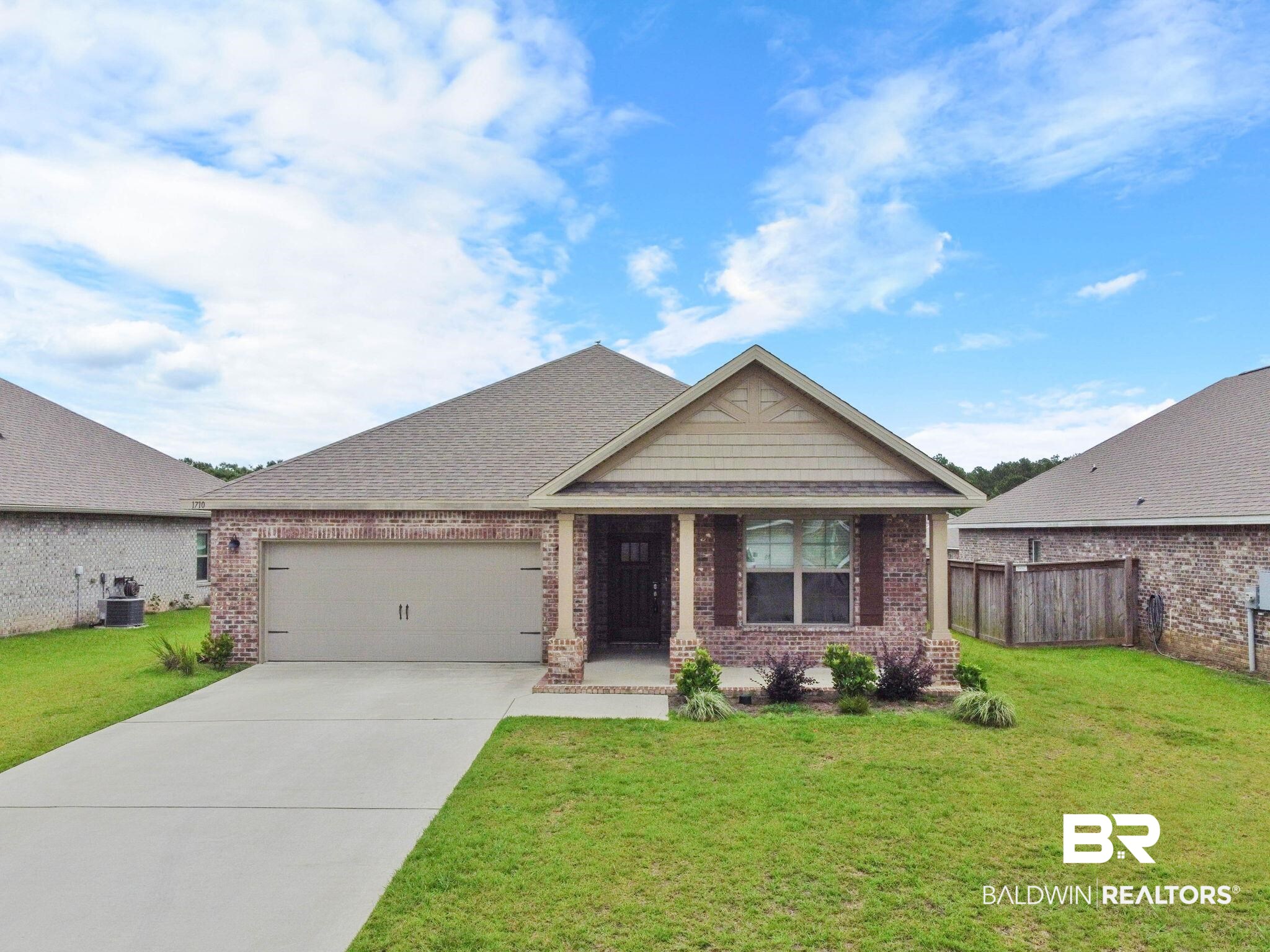 1710 Grouse Street Foley, AL 36535 - Photo 3 of 76 Brick exterior featuring a gabled roofline, an attached single-car garage, and a concrete driveway