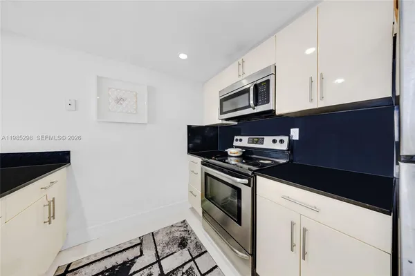 a kitchen with stainless steel appliances granite countertop a stove and a microwave