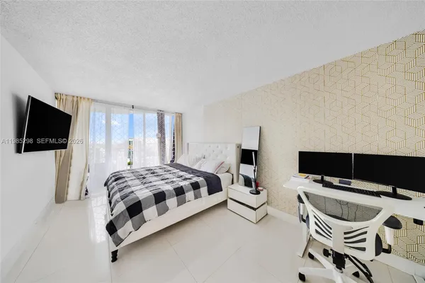 a bedroom with a bed and flat screen tv