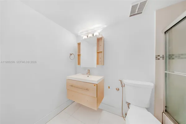 a bathroom with a sink mirror vanity and toilet